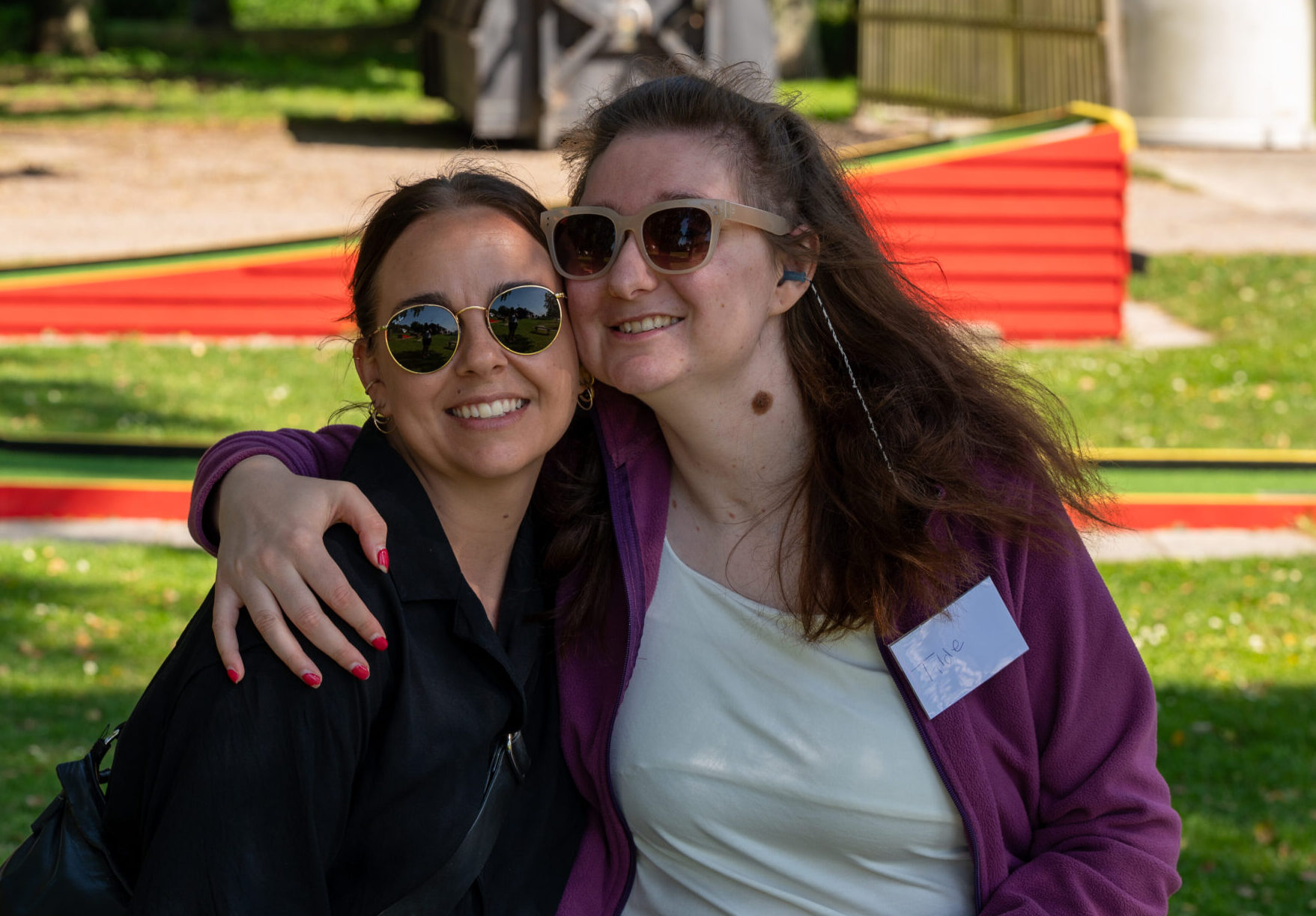 Två unga kvinnor som ler och håller om varandra