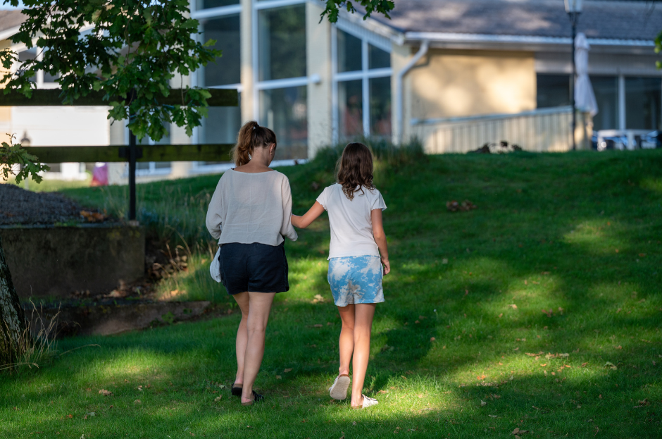 Två unga kvinnor bakifrån som håller i varandra